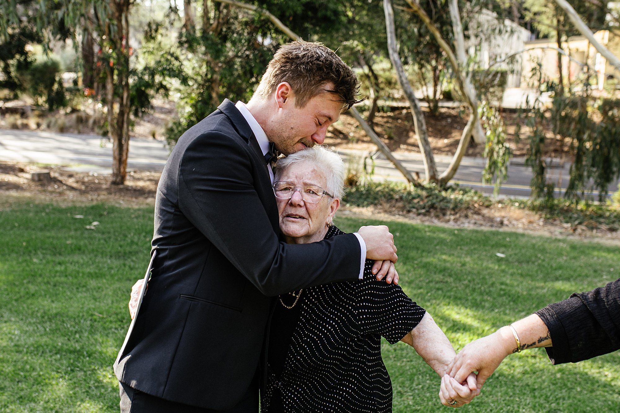 Groom hugging his nan during the wedding, tearing up in an emotional moment. 