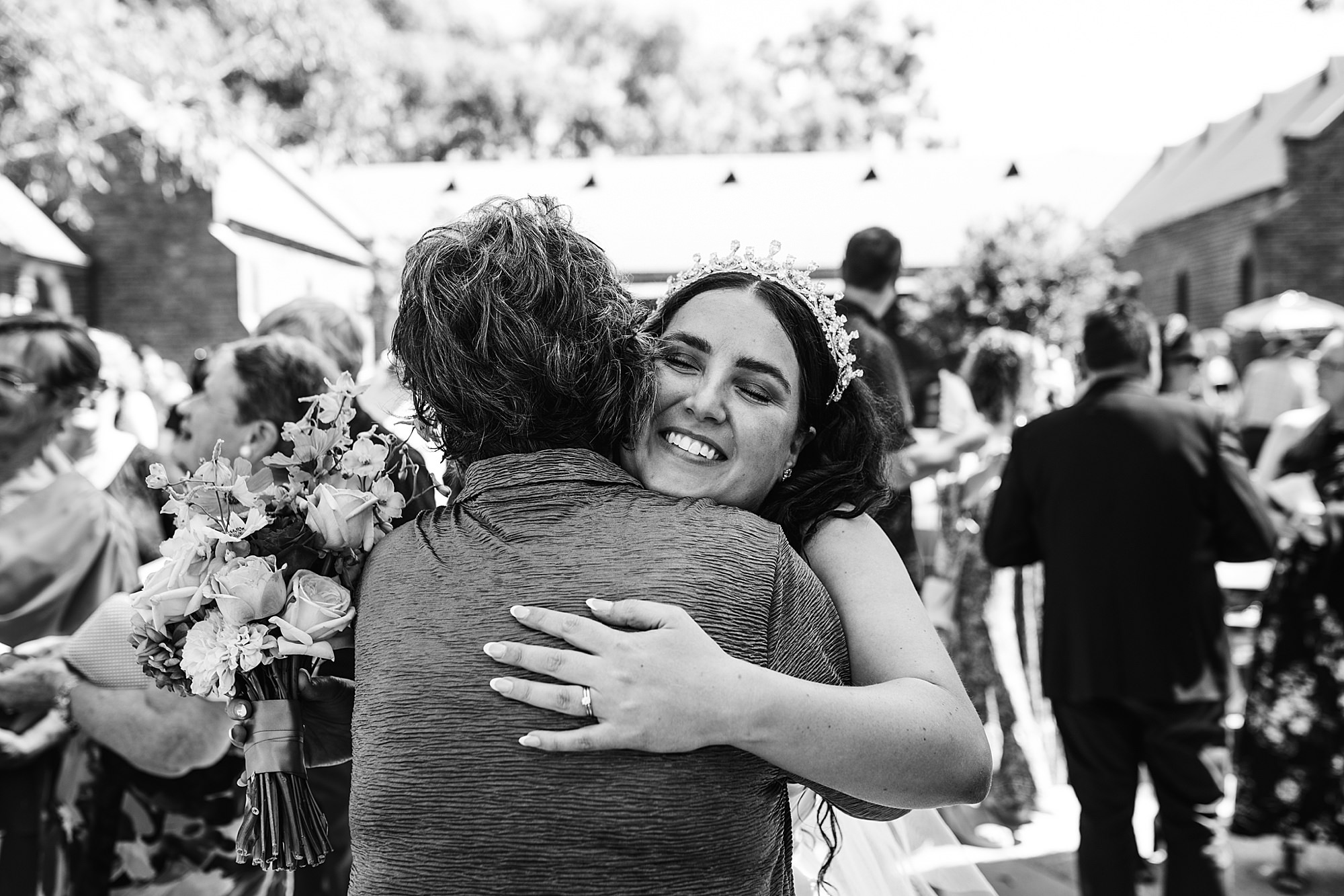 Joyful moment of the bride hugging her guests after the wedding ceremony. 