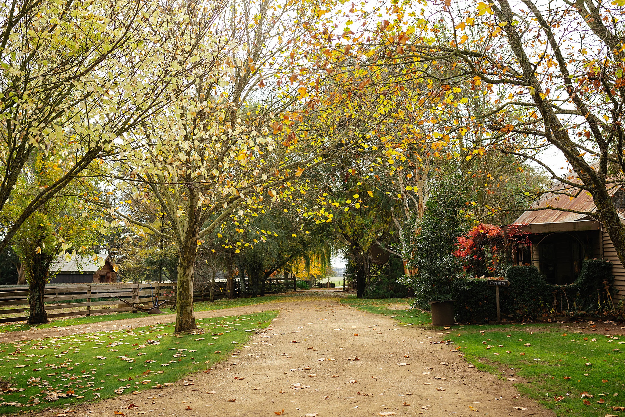 A charming pathway winds through beautiful autumn and winter hues of orange and green, creating a romantic setting at this picturesque stables wedding venue.