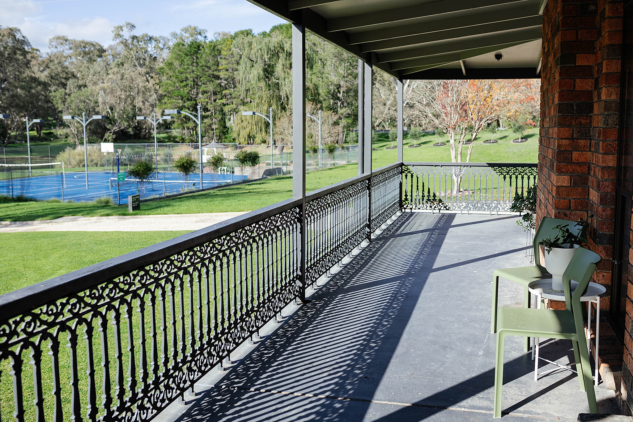 Patio overlooking grass and tennis courts at Trawool Estate.